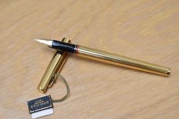 A boxed Caran d'Ache Ambassador converter/ cartridge fill fountain pen, gold plated with red and
