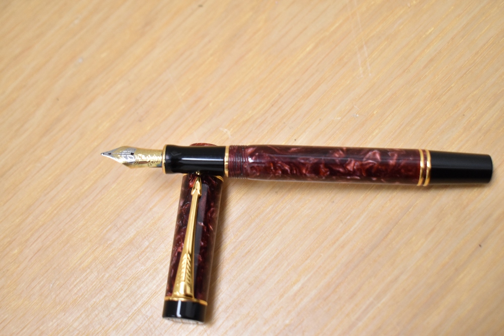 A Parker Duofold International Cartridge fill fountain pen in red swirl with one broad and one