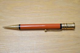 A Parker Duofold propelling pencil in red with black band to top and bottom of the barrel