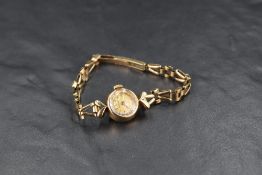 A lady's vintage 9ct gold wrist watch by Omega having baton numeral dial to champagne face in gold