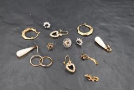Seven pairs of 9ct gold and yellow metal earrings of various forms including hoops, sapphires,