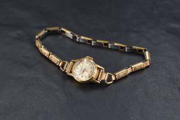 A lady's vintage 18ct gold wrist watch by Mu Du having Arabic & baton numeral dial to small face