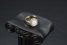 An opal and diamond chip cluster in a stepped claw mount on a 9ct gold loop, size J & approx 2.7g