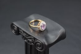 An amethyst and diamond chip cluster ring having an illusionary setting on a 9ct gold loop, size K &