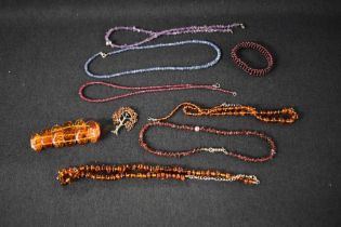 A selection of strings of beads including Baltic amber, rough cut amethyst and garnet, baltic