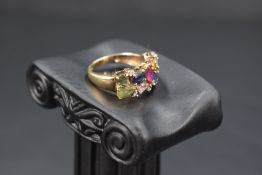 A fancy sapphire multi coloured ring having fourteen stones in a claw set double row on a 9ct gold