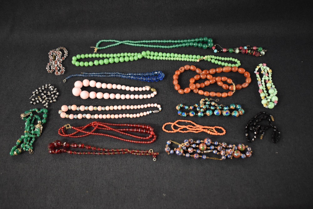 A vintage travel case containing a selection of vintage strings of beads including carnelian, coral,