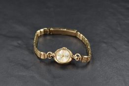 A lady's vintage 9ct gold wrist watch by Accurist having baton numeral dial to small face in gold