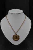 A gold sovereign dated 1968 in a 9ct gold decorative removable mount on a 9ct gold chain, approx