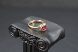 A ruby ring having a facet cut circular stone in a collared mount on a 9ct gold loop, size O/P &