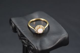 An opal and diamond cluster ring (1 diamond missing) having claw set mount, knife blade shoulders