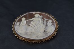A conch shell cameo brooch depicting Venus riding dolphins in a 9ct gold decorative mount, approx