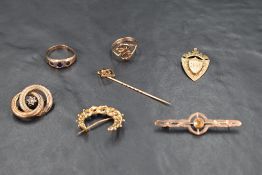 A selection of 9ct gold and yellow metal jewellery including three brooches, a medalion and two