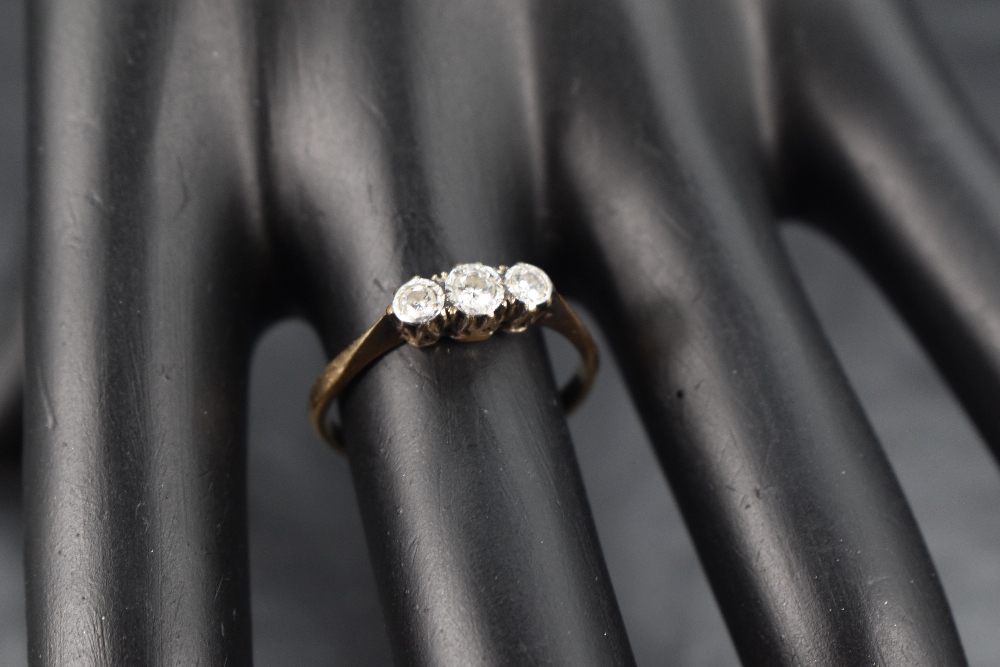 A diamond trilogy ring having three small diamonds in an illusionary mount on an 18ct gold loop, - Image 2 of 2
