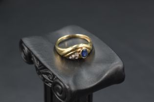 A 9ct gold moulded band ring having a collared sapphire with diamond chip decoration, size R &