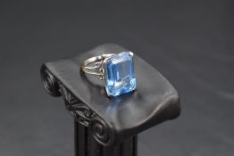 An oversized baguette cut blue topaz ring in a four claw basket mount on an 18ct white gold loop,