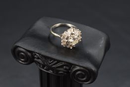 An open diamond cluster ring having a central brilliant cut diamond, approx 1ct within a frilled