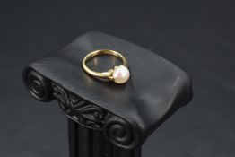 A cultured pearl solitaire ring having split shoulders and an 18ct gold loop, size G & approx 2.2g