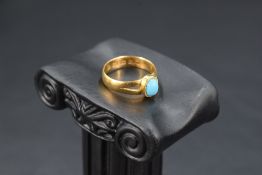 A Victorian 22ct gold ring having small oval turquoise cabochon in collared mount to split shoulders