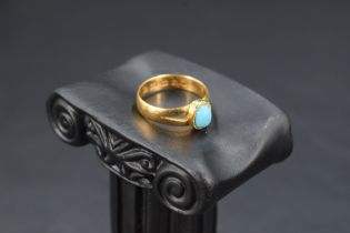 A Victorian 22ct gold ring having small oval turquoise cabochon in collared mount to split shoulders