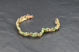 A damaged yellow metal bracelet having green enamelled decoration, no marks but tests as 18ct