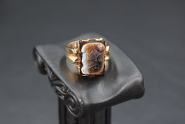 A gent's 9ct rose gold signet ring having a rectangular panel with centurion decoration, size T &