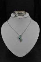 A silver and faux opal four piece jewellery suite comprising of pendant, earrings, ring and