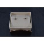 A pair of champagne diamond solitaire stud earrings, each stone approx 0.125ct in 14ct white gold