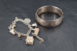 A silver hinged bracelet having engraved scroll decoration and inscription inside dated 1960, and