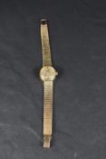 A ladies 9ct gold wrist watch by Omega having baton numeral dial and date aperture to champagne