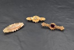 Two 9ct gold bar brooches and a similar 15ct gold bar brooch, all having precious stone and wire