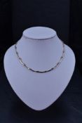 A 9ct gold necklace having shaped bar and link spacers, approx 16' & 14.2g