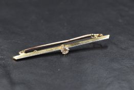A yellow metal bar brooch stamped 18ct having central diamond, approx 0.25ct & 3.4g
