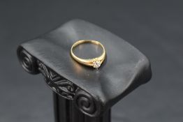 A diamond solitaire ring, approx 0.128ct in a claw set mount to split shoulders on an 18ct gold