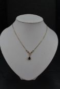 A 9ct gold and garnet necklace having collared stones with teardrop drop and fixed chain, approx 16'