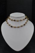 A 9ct gold necklace having gold brushed ball and tigers eye bed decoration with chain connectors,