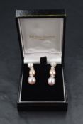 A pair of 18ct white gold stud earrings having cultured pearl stud with four stone diamond fixed