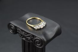 A five stone graduated diamond ring, total approx 1.25ct in a claw set raised mount on a yellow