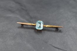 A 9ct gold bar brooch having central baguette cut blue topaz stone, approx 3.5g