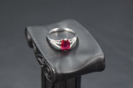A baguette cut ruby ring approx 1ct in a claw set mount to diamond set split shoulders on a white
