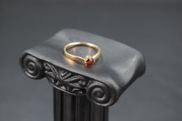 A garnet solitaire ring on a 15ct gold loop, size M & approx 1.5g