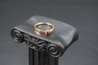 A garnet solitaire ring on a 15ct gold loop, size M & approx 1.5g