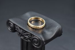 A 9ct gold wedding band having cut detail, size O & approx 2.2g