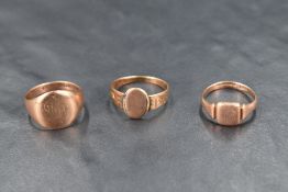 Two 9ct rose gold signet rings of worn form and a similar yellow metal signet ring, approx 9g total