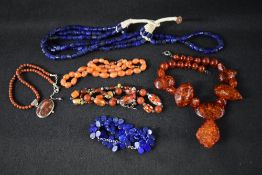 A selection of strings of beads including lapis lazuli, carnelian, Baltic amber style etc