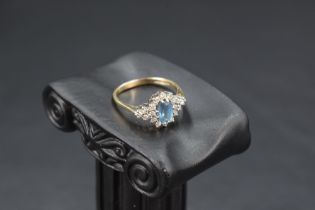 A blue topaz and diamond cluster ring flanked by a further trio of diamonds to each side, total