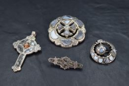 Three Scottish/Celtic white metal brooches of various forms having polished agate and granite