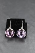 A pair of silver loop drop earrings by Baccarat having purple glass moulded discs on silver