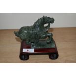 A Chinese green stone rearing horse ornament on hardwood stand, measuring 14cm high overall