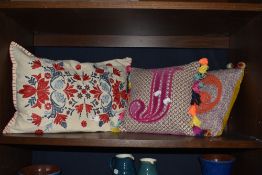 A trio of cheerful scatter cushions, one with Portuguese style embridery and two with appliqué